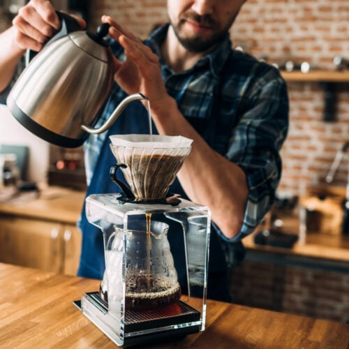 man-prepares-coffee-in-pour-over-style