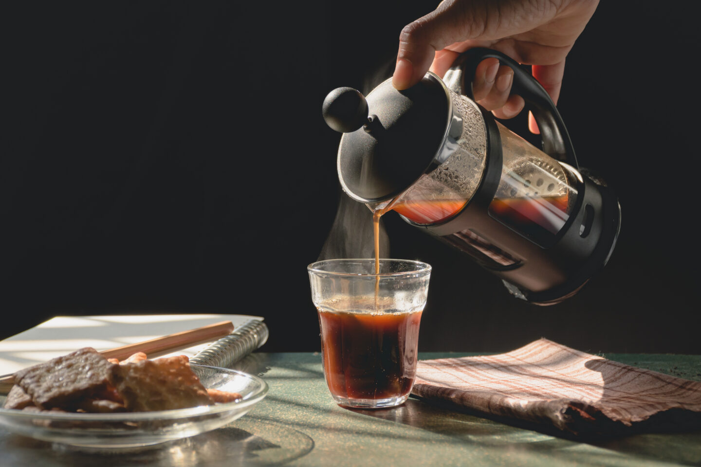 pouring-hot-coffee-from-a-french-press-with-dark-background