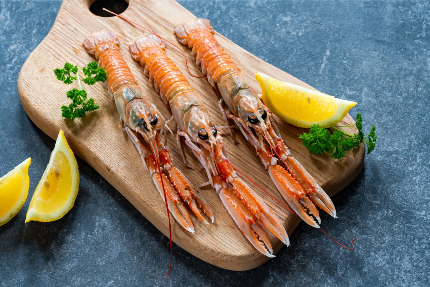 raw langoustines with lemon wedges