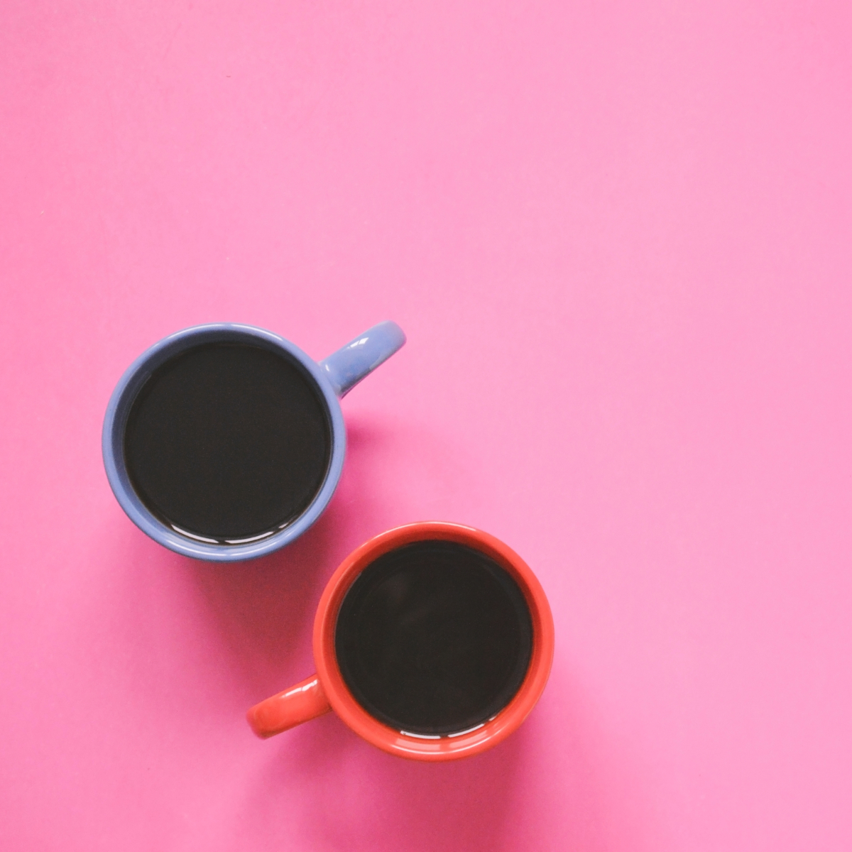 red-cup-and-bue-cup-of-coffee-on-a-pink-table