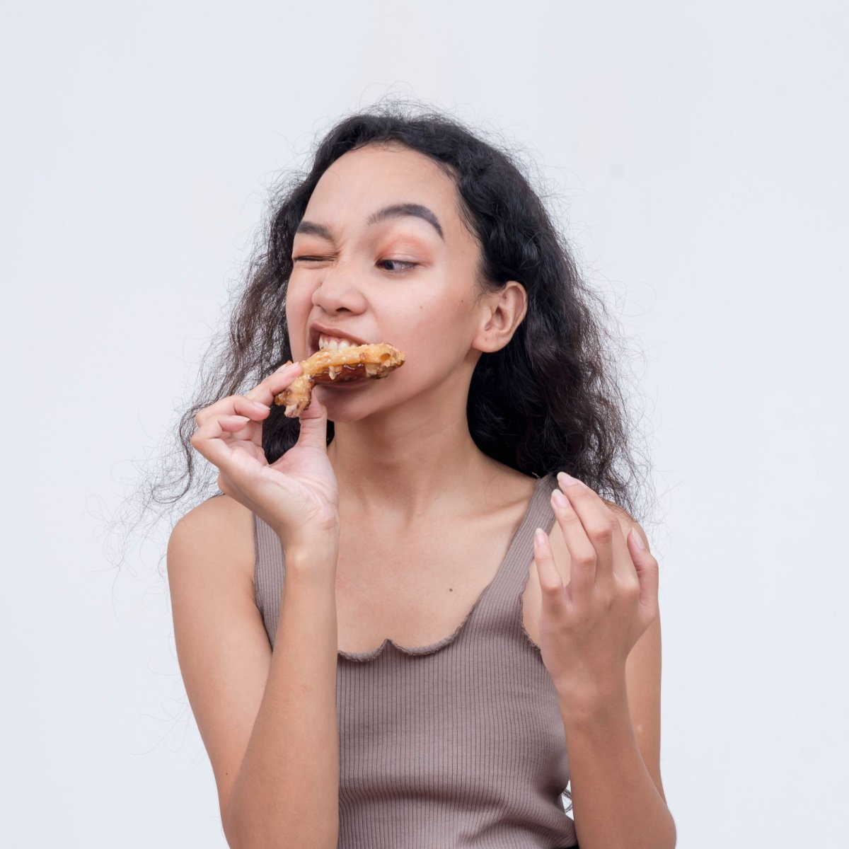 woman bites on tough chicken meat