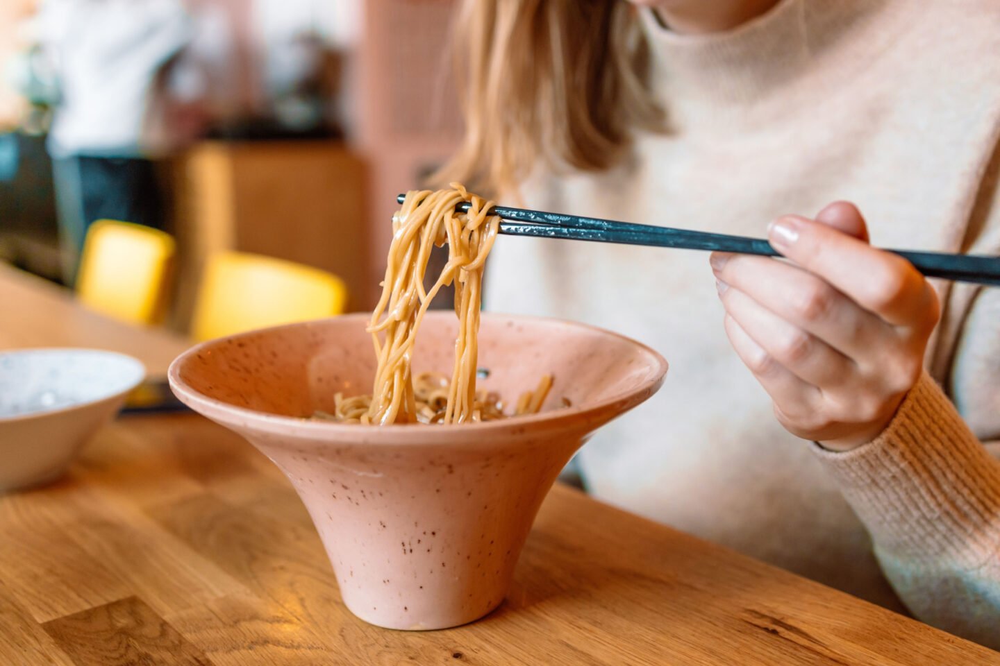 woman eating instant noodles with chopsticks