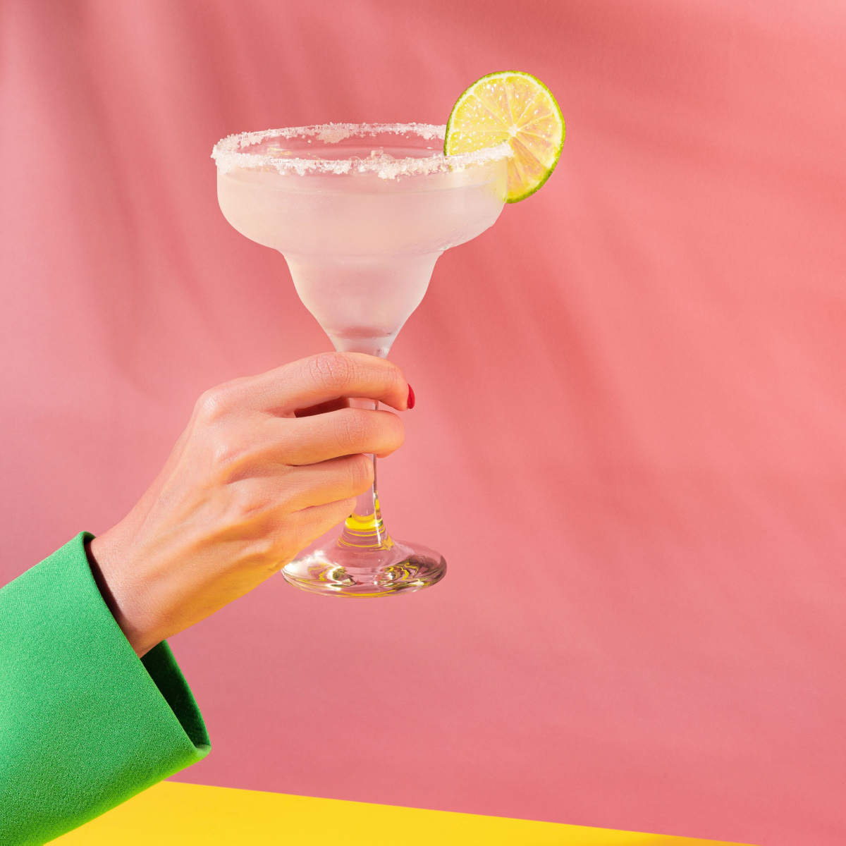 woman holding margarita in salt rimmed glass