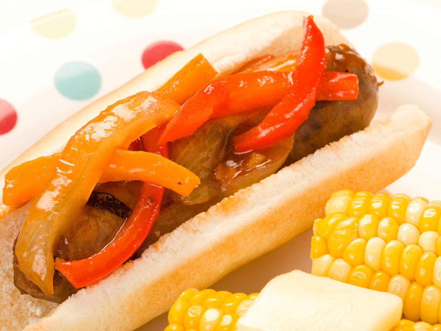 Italian sausage and peppers on a bun with buttered corn