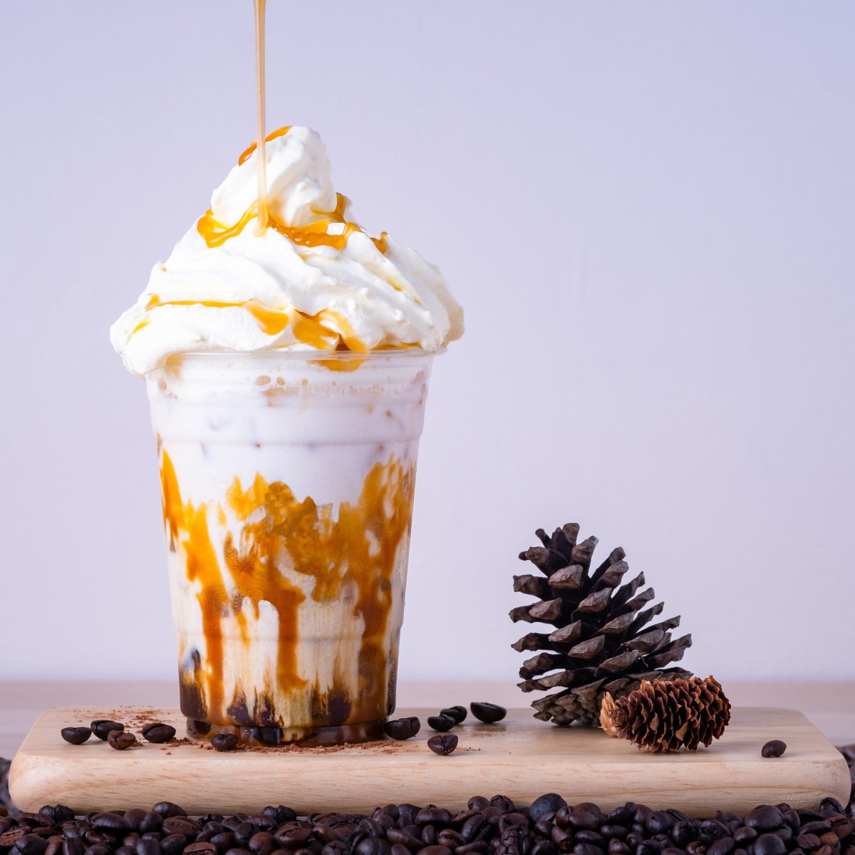 caramel-macchiato-coffee-milk-and-caramel-syrup-in-glass-on-wooden-table