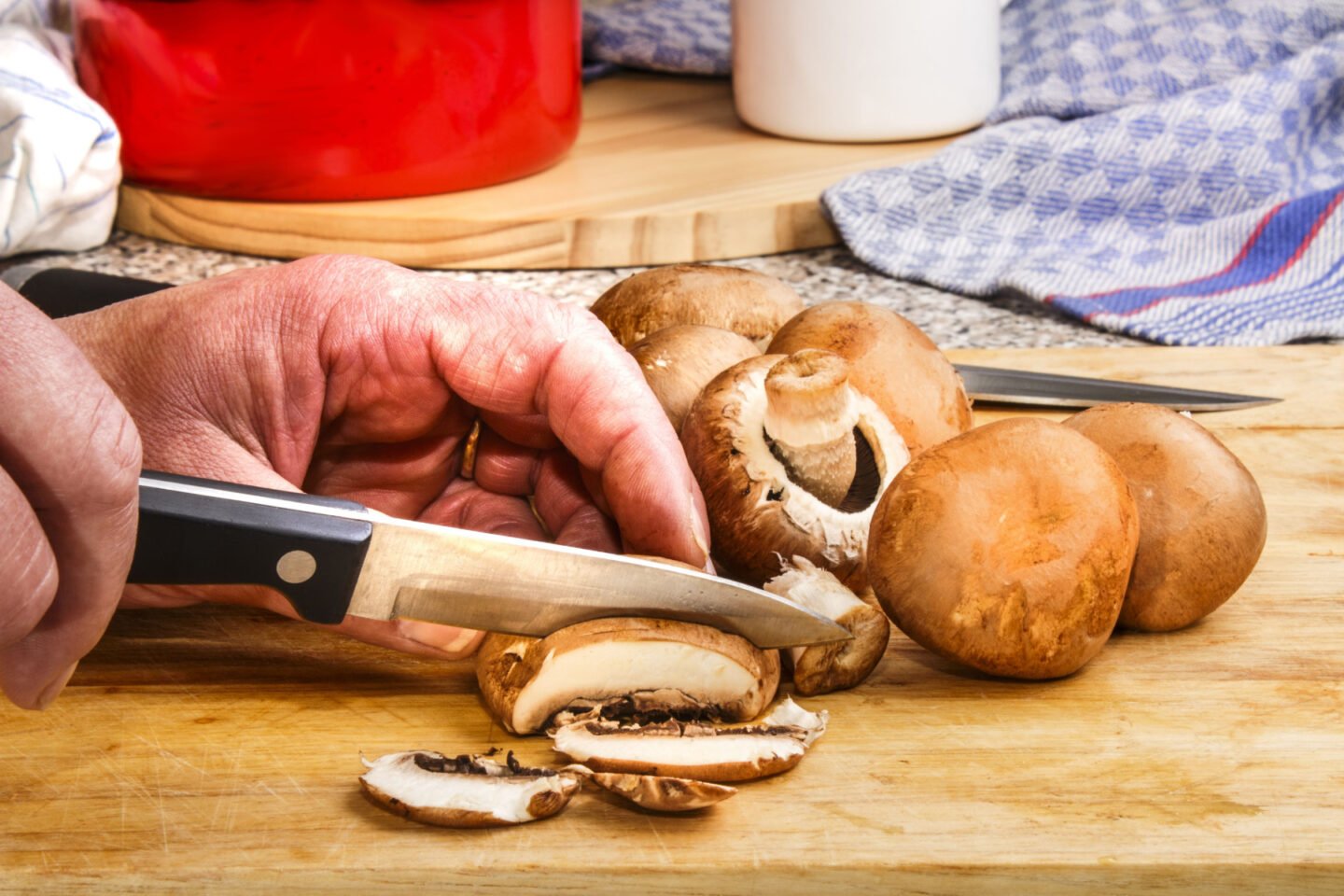 chef cuts chestnut mushrooms
