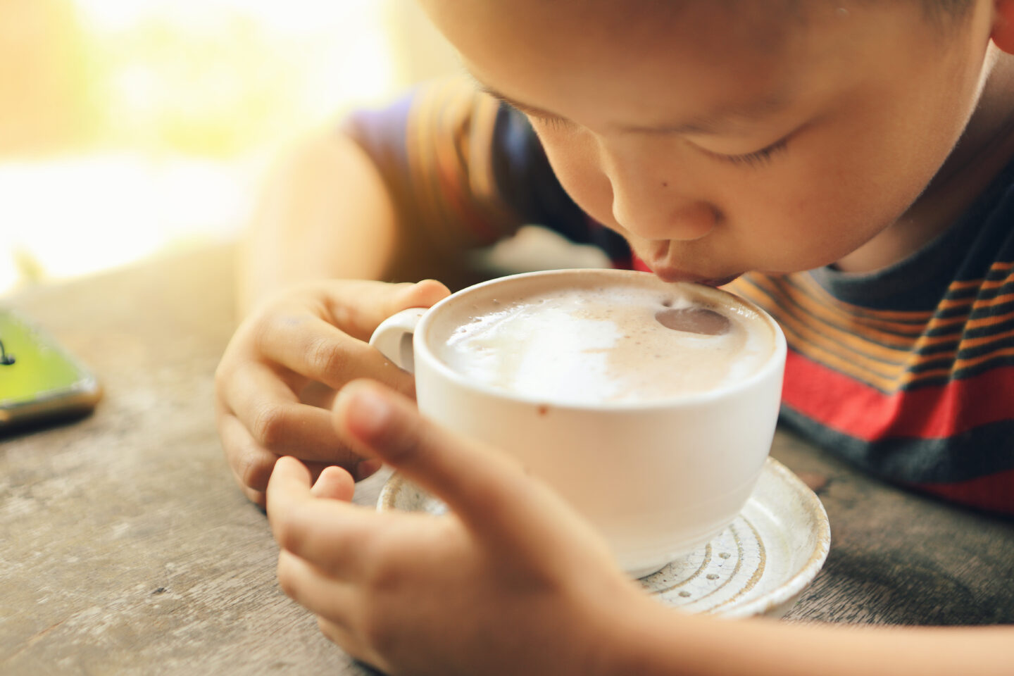 child-drinking-coffee-from-a-white-cup