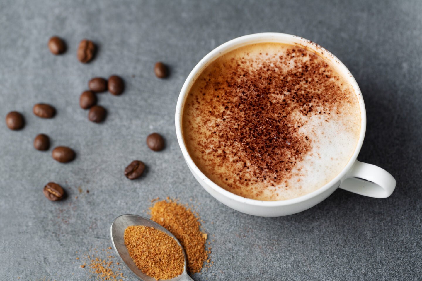 Tasty,Appetizing,Cappuccino,In,Cup,With,Beans,On,Concrete,Background.