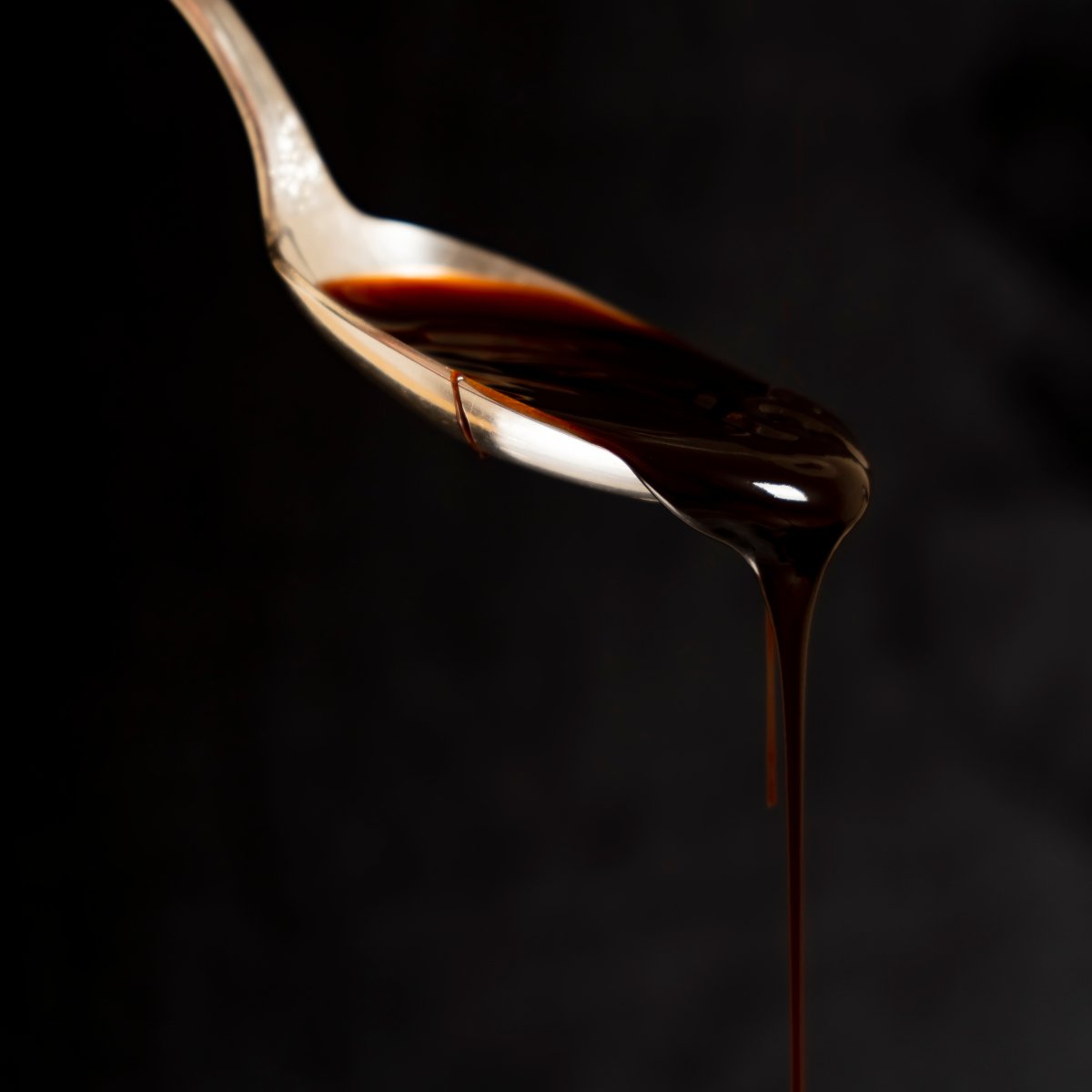 dark-caramel-sauce-dripping-from-a-spoon