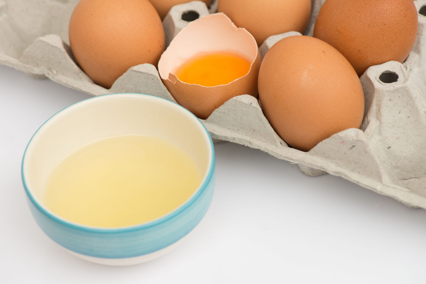 egg whites in a bowl with fresh eggs in a tray