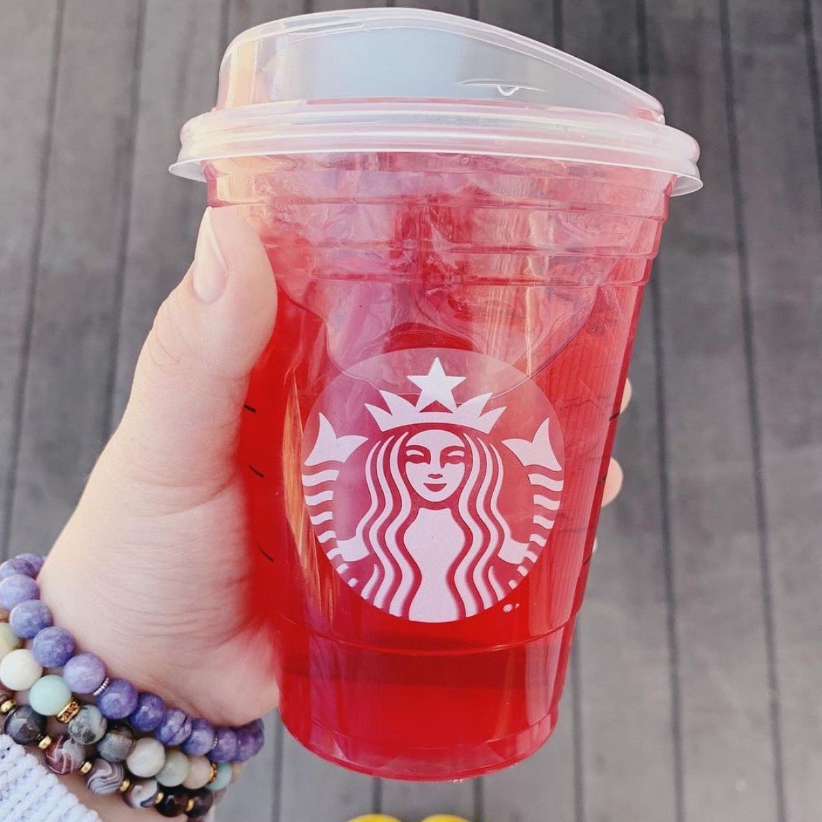 hand holding cup of starbucks strawberry acai refresher