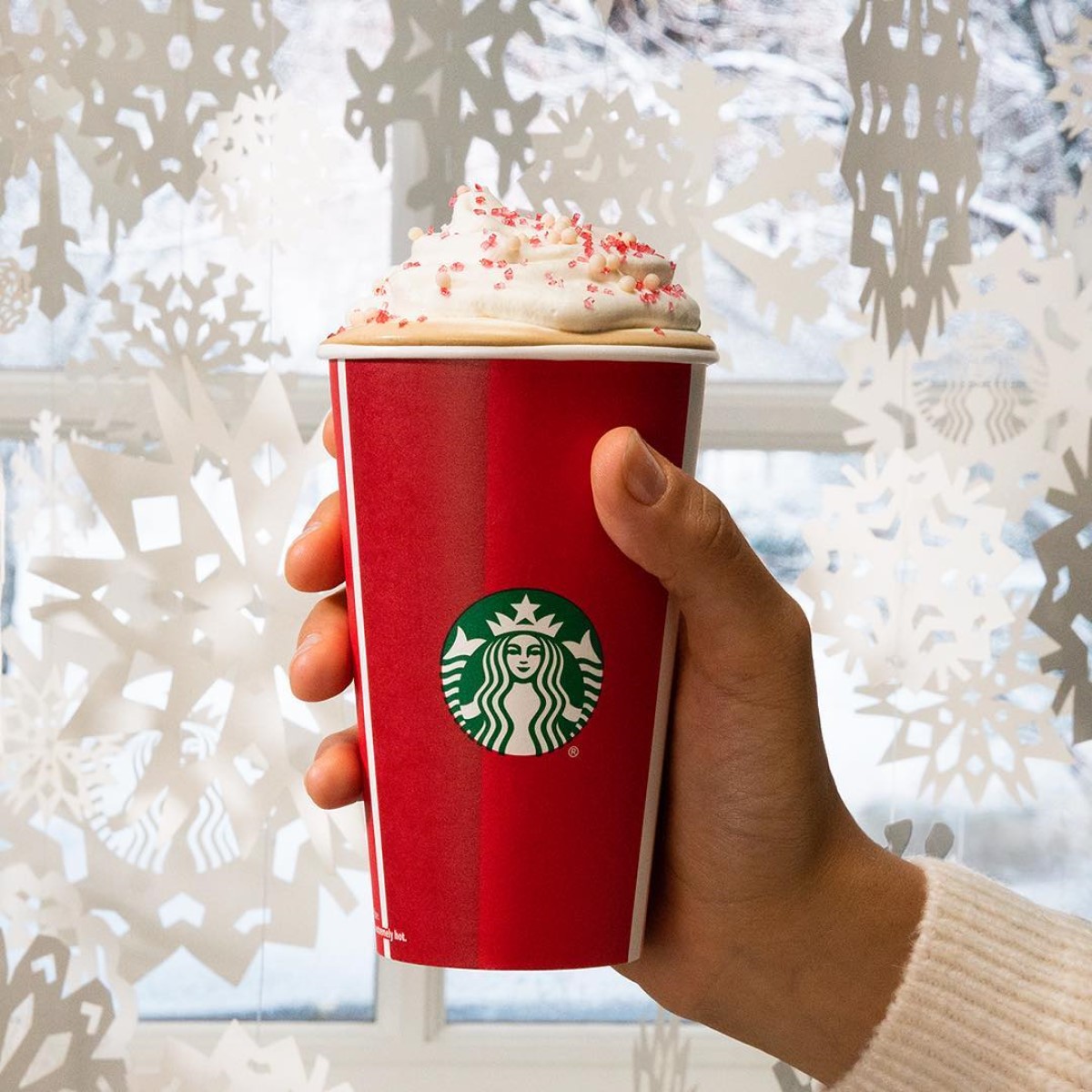 hand holding starbucks toasted white hot chocolate mocha in red paper cup