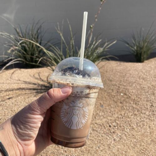 man holding a marble frappe outdoors