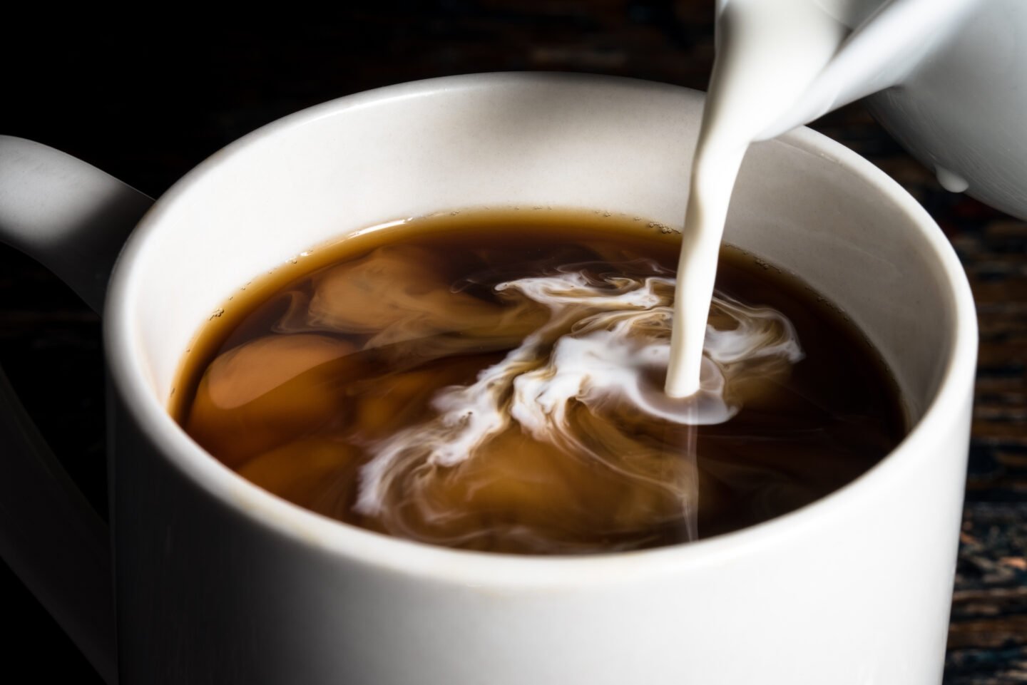 pouring-creamer-into-a-cup-of-coffee