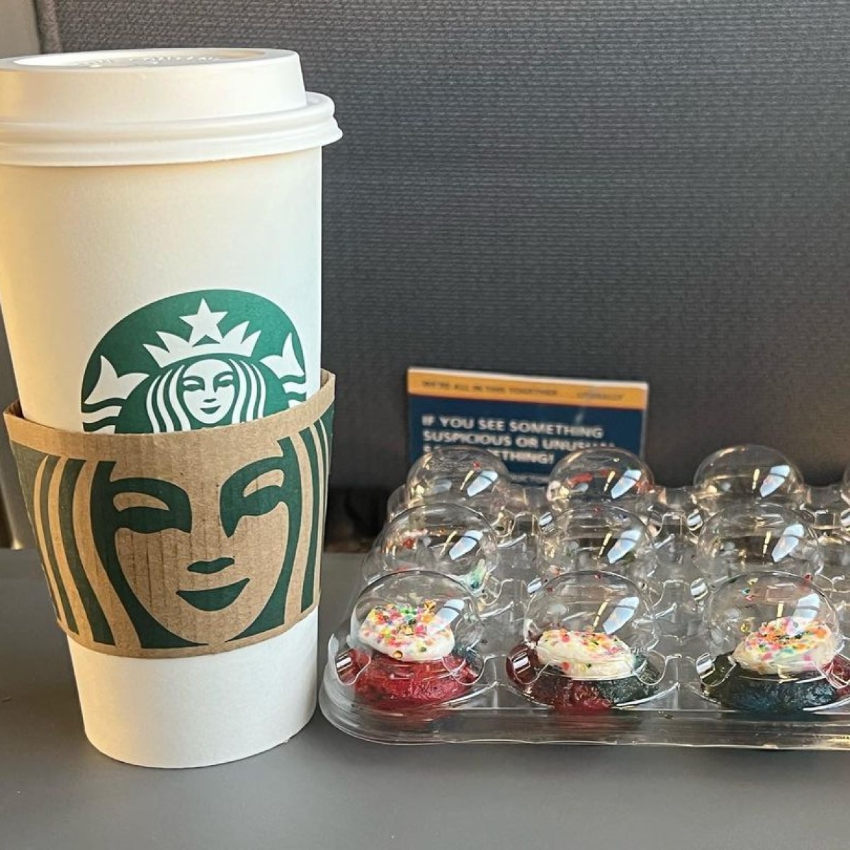 starbucks steamed apple juice in takeaway paper cup beside tie dye cupcakes