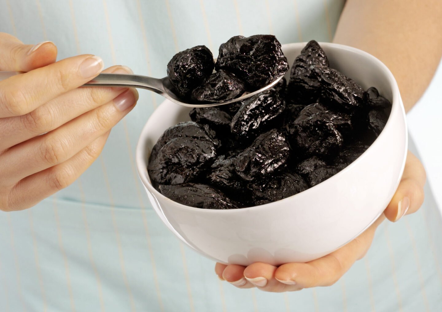 woman holding a bowl of prunes
