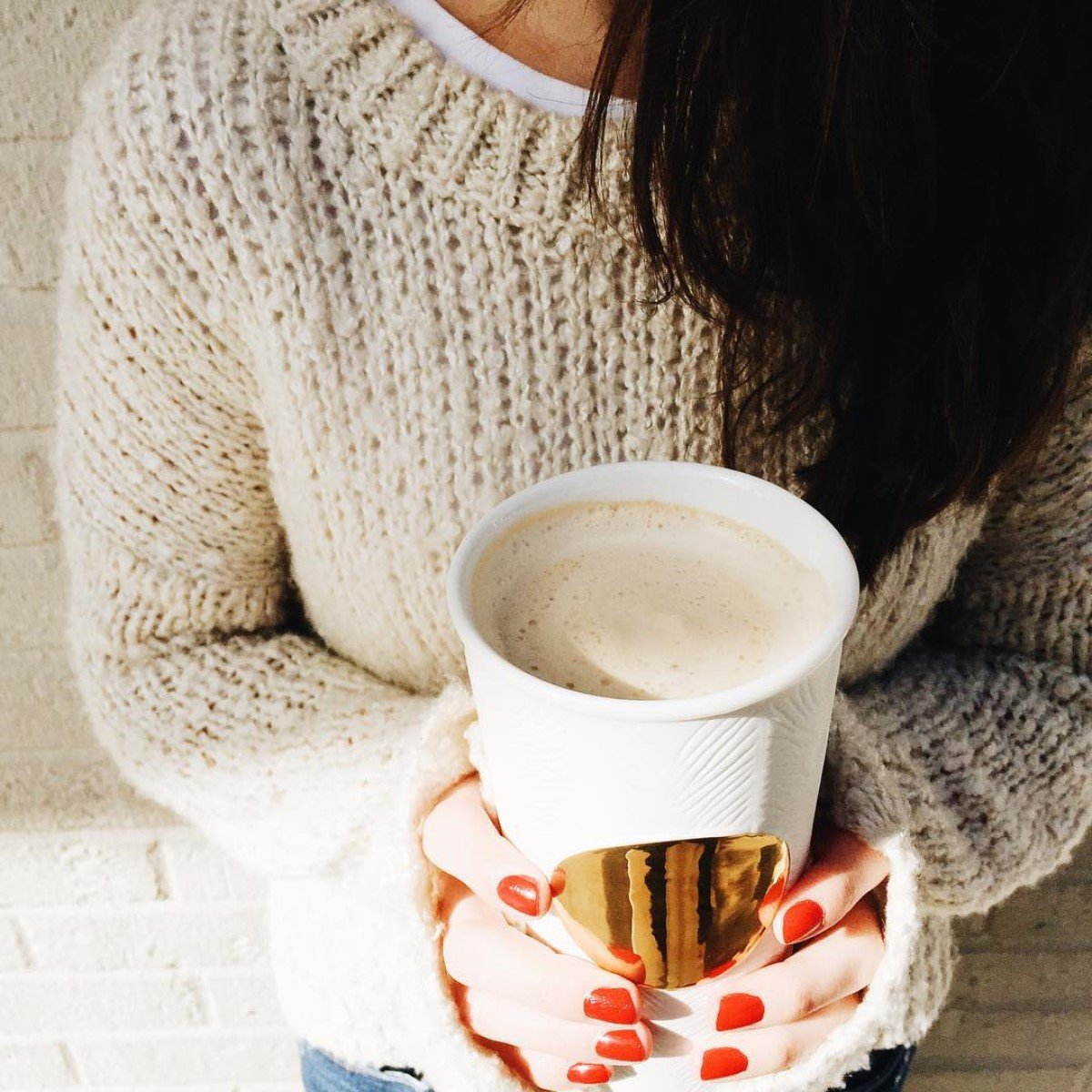 woman holding cup of starbucks hot chai tea latte