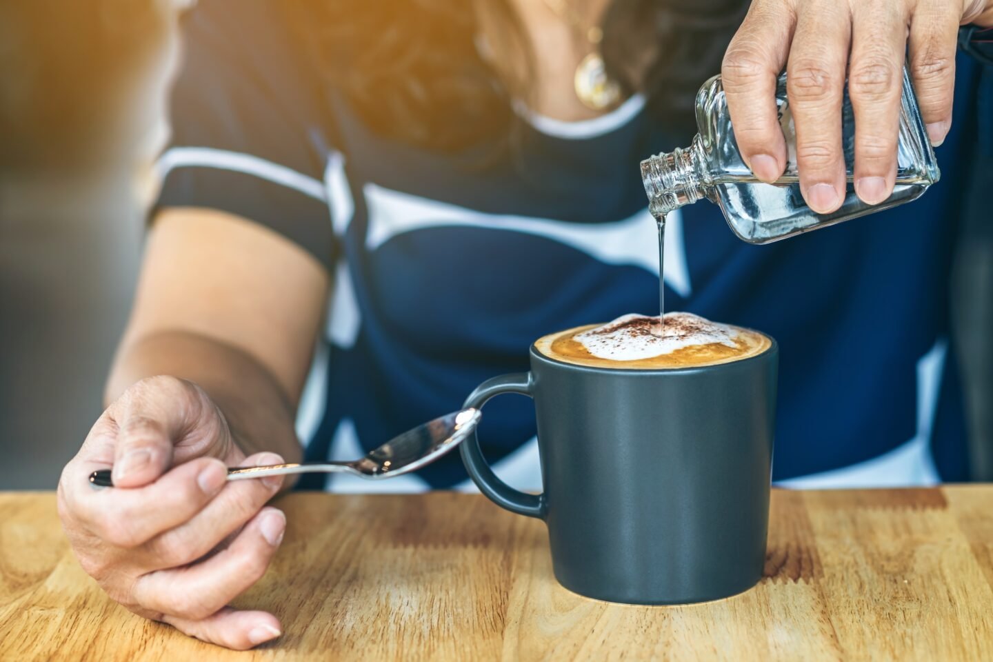 woman-pouring-syrup-into-hot-coffee