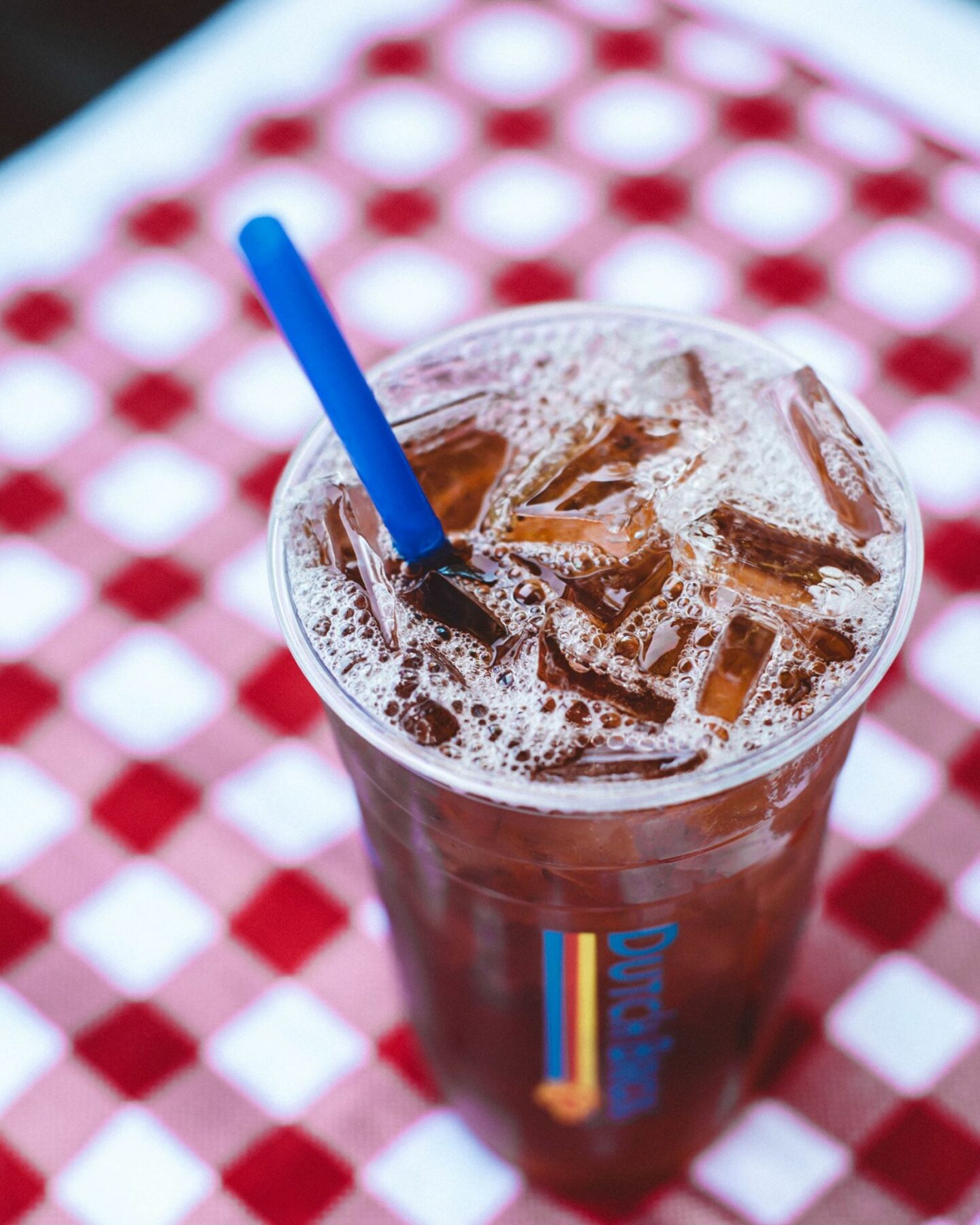 dutch bros iced peach black tea on red checkered pattern