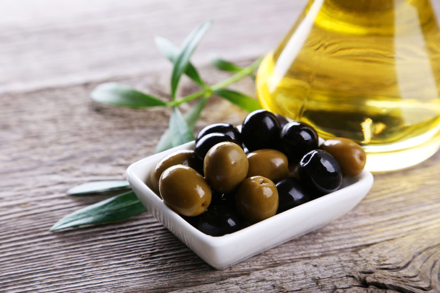 green black olives with bottle of olive oil