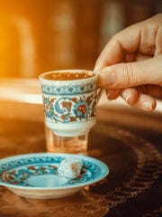 hand-of-a-woman-holding-a-traditional-porcelain-turkish-coffee-cup
