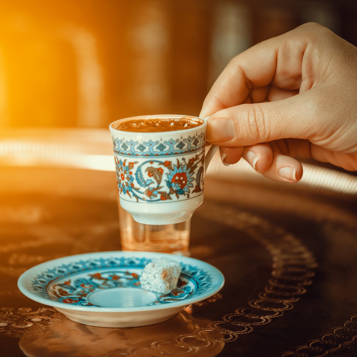 hand-of-a-woman-holding-a-traditional-porcelain-turkish-coffee-cup