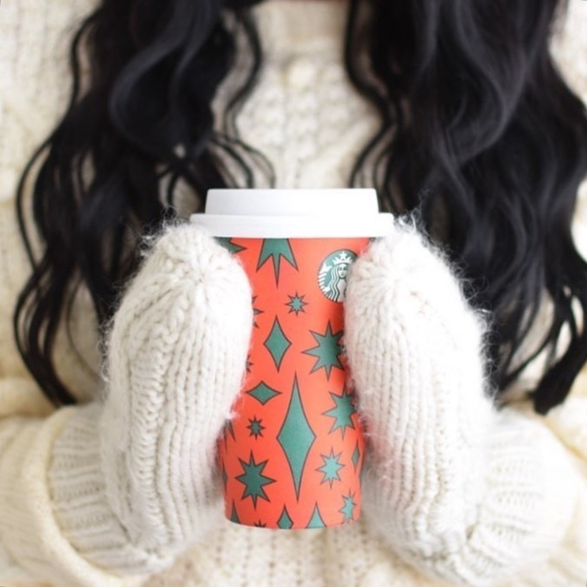 woman holding red starbucks cup of peppermint cold foam cold brew between mittens