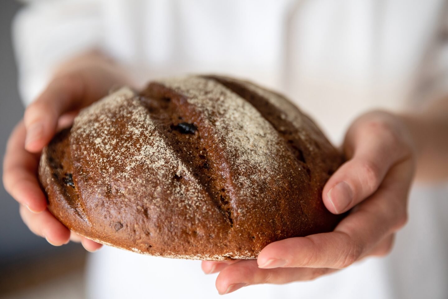 Homemade crusty loave of bread. Baker holding fresh bread in the