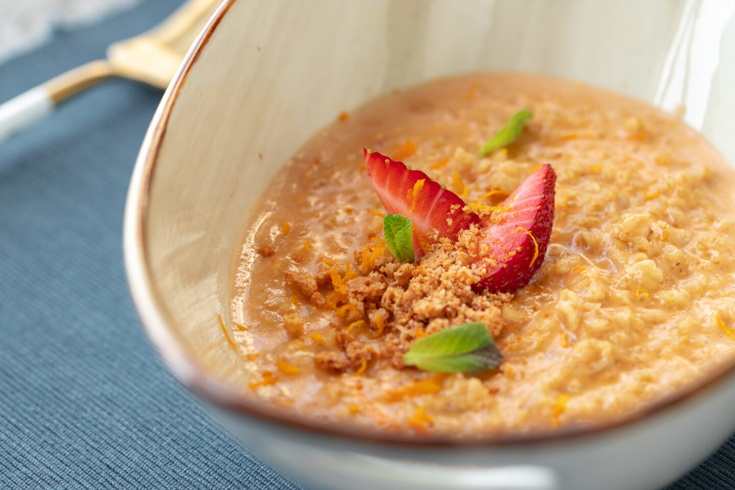 Bowl of oatmeal porridge with strawberry and mint