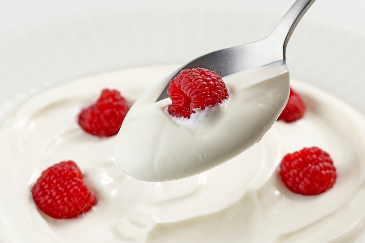 spoon of greek yogurt with raspberry