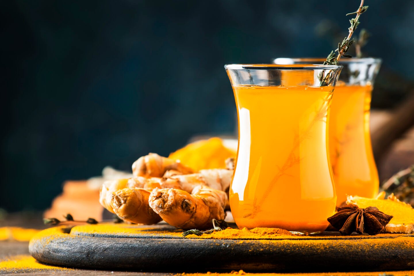 Healthy vegan turmeric golden tea with honey in glass cup on woo