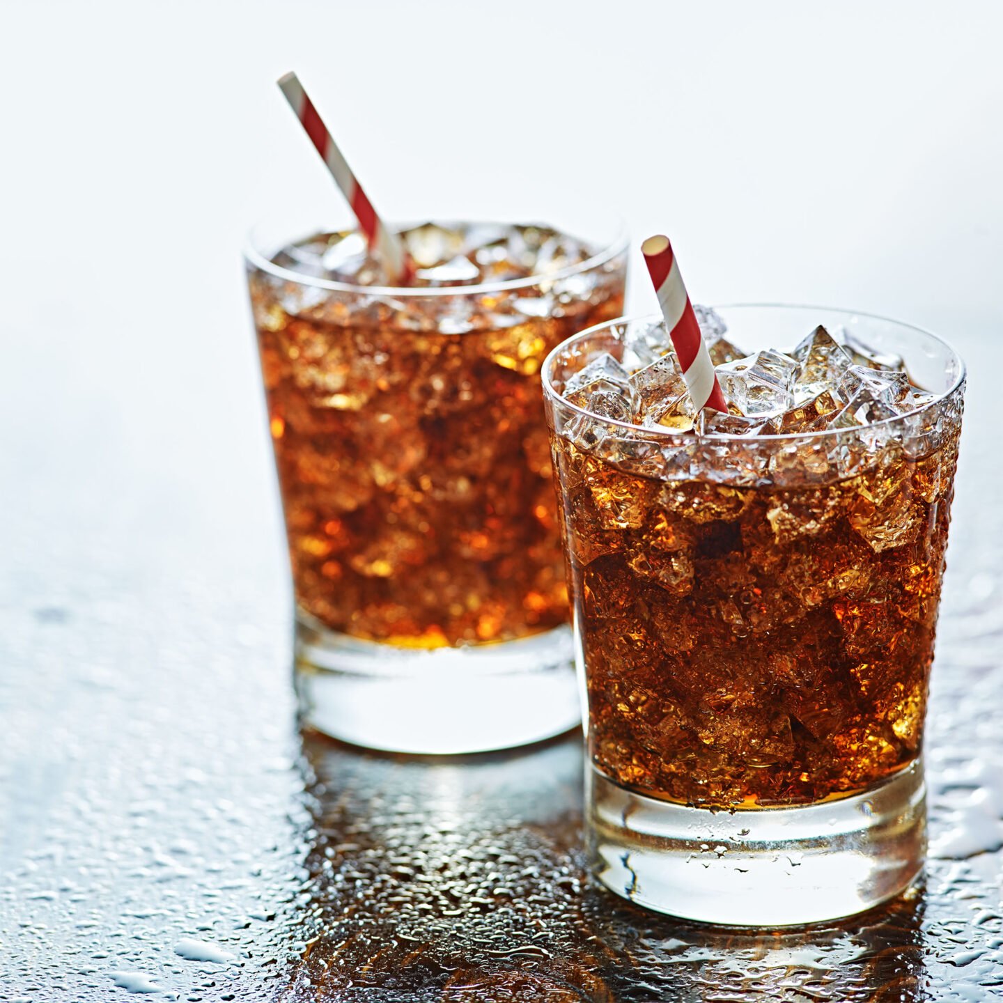 cold glass of cola with striped straw
