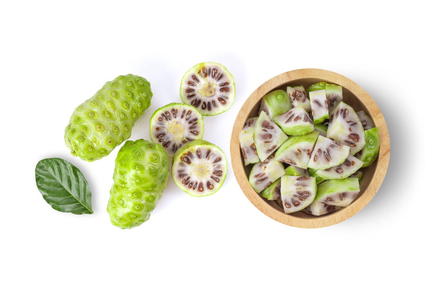 noni fruit slices in wood bowl
