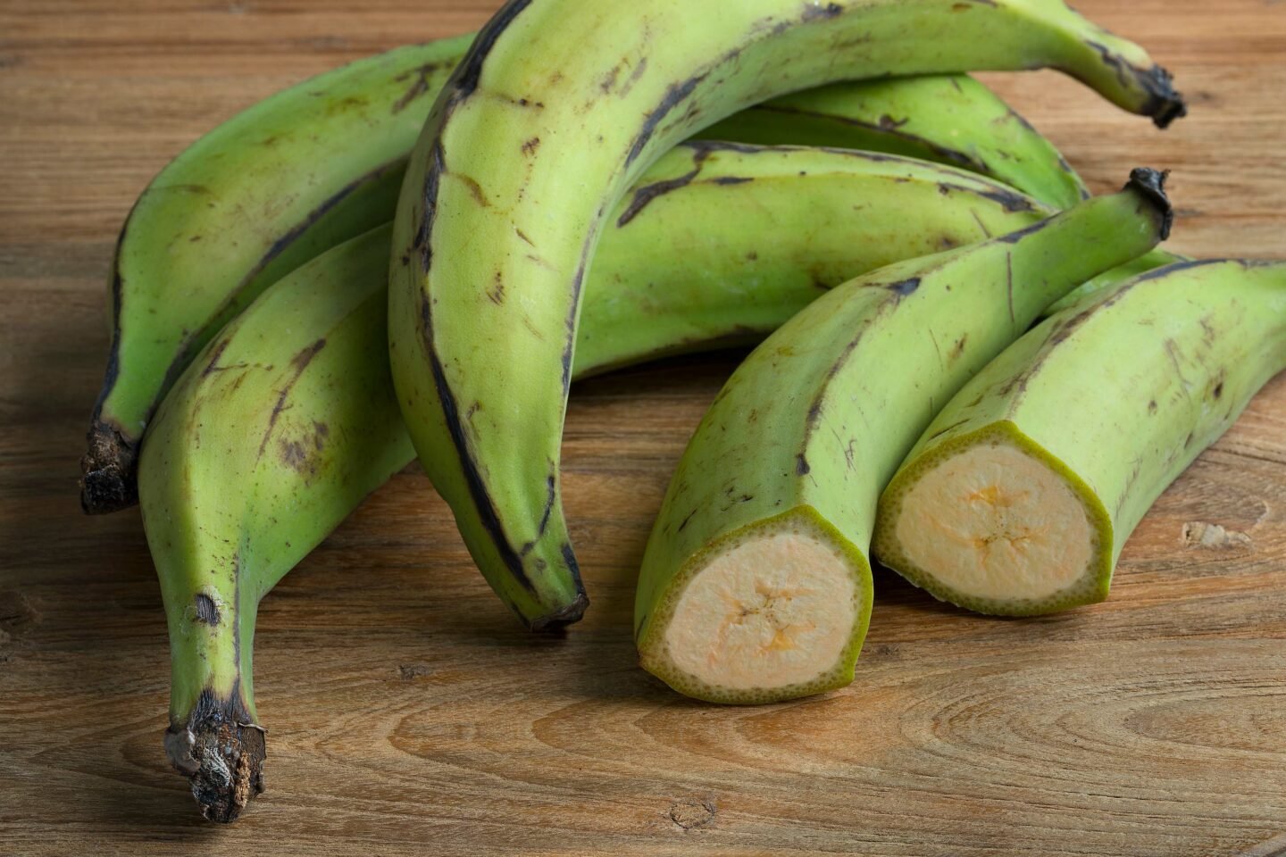 whole and half green unripe bananas