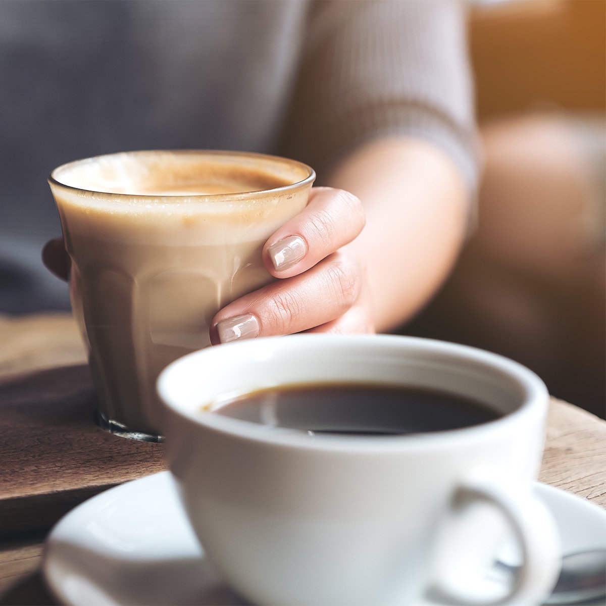 americano coffee cup and woman holding a cup of latte