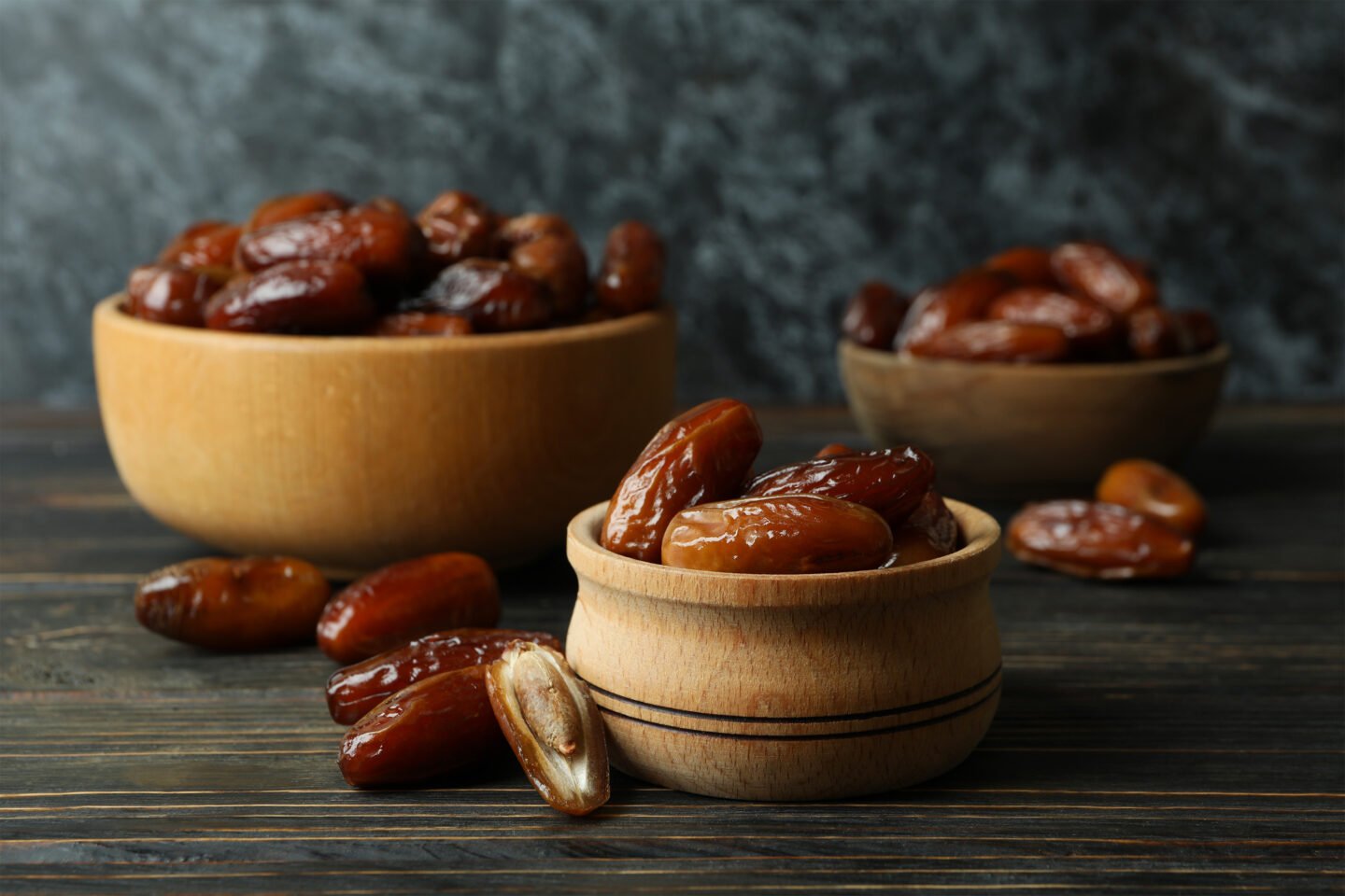 bowl with dried dates on wooden table
