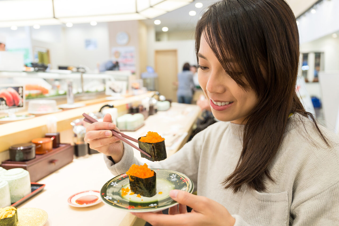 asian woman eating sushi