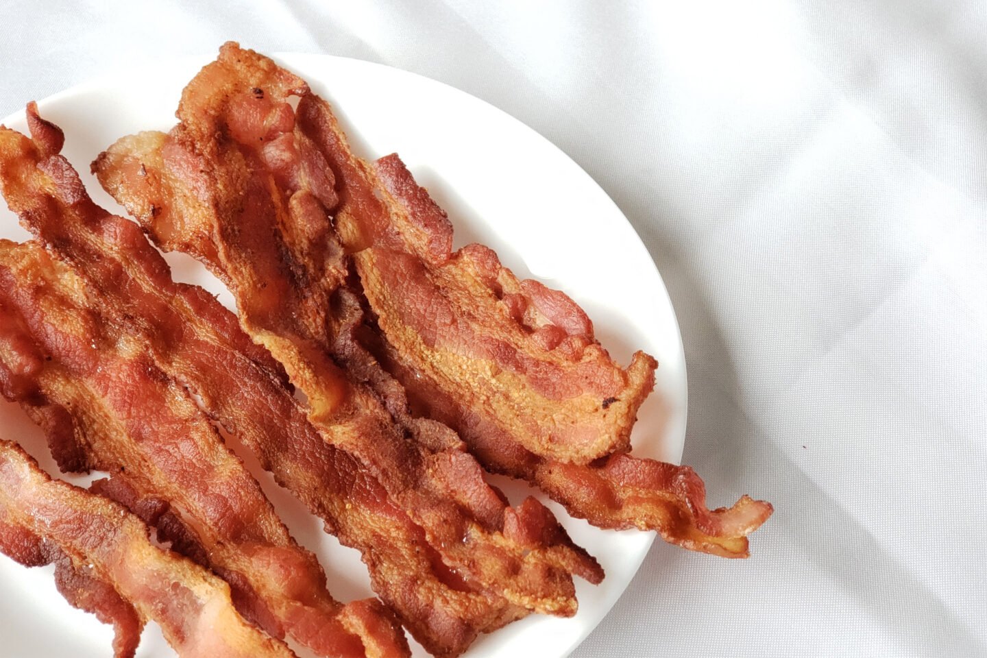 strips of bacon freshly fried served on a plate