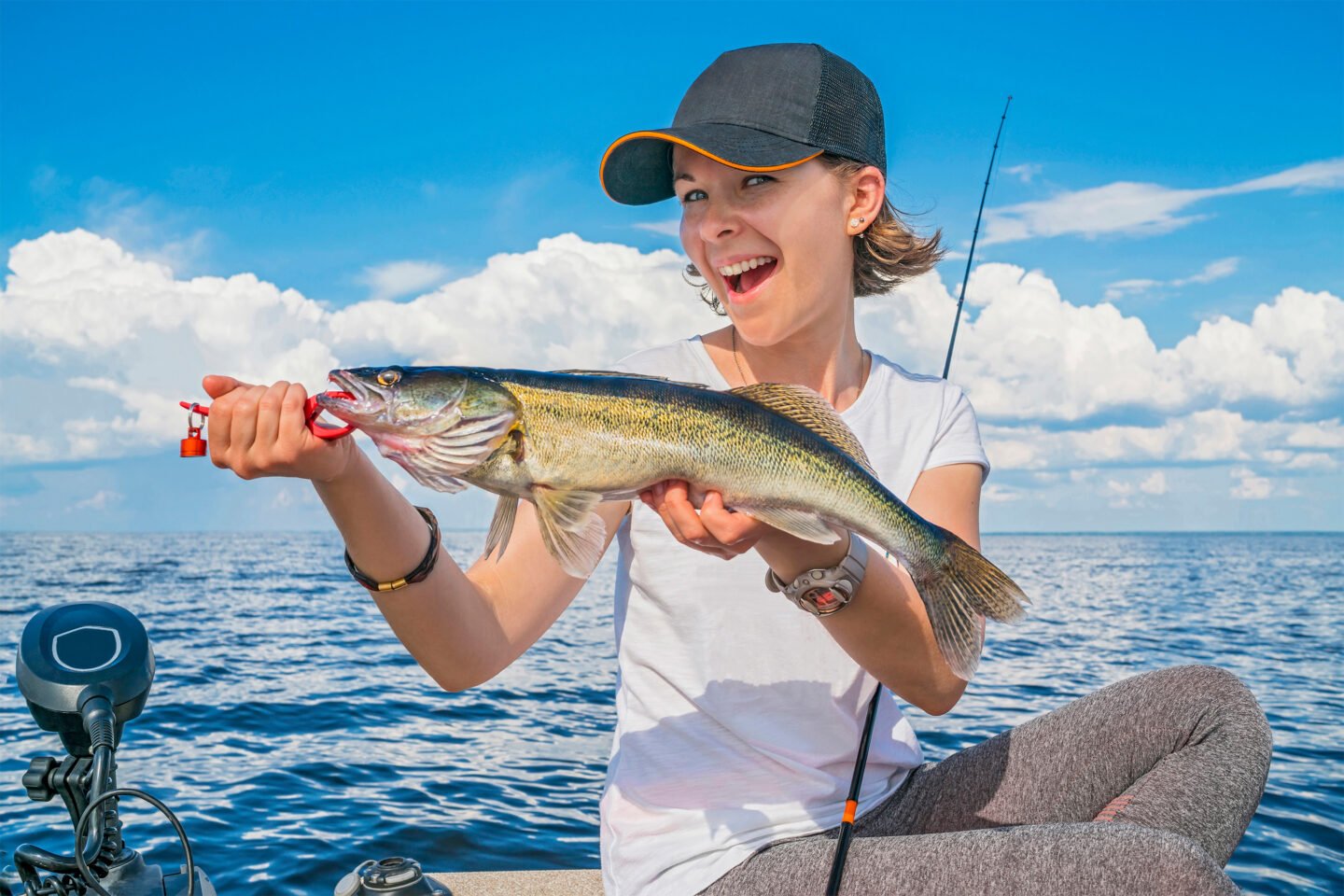 happy woman holding walleye fish