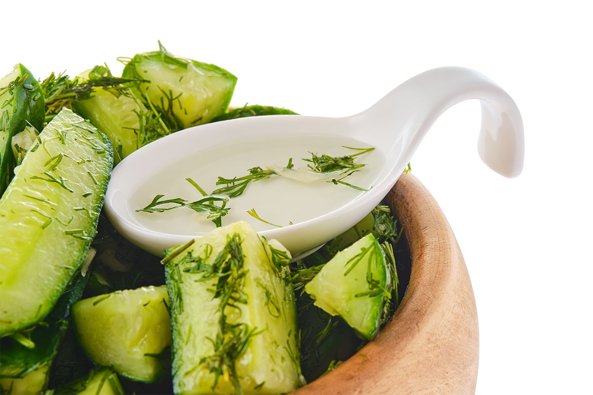cucumber and dill with white vinegar in spoon