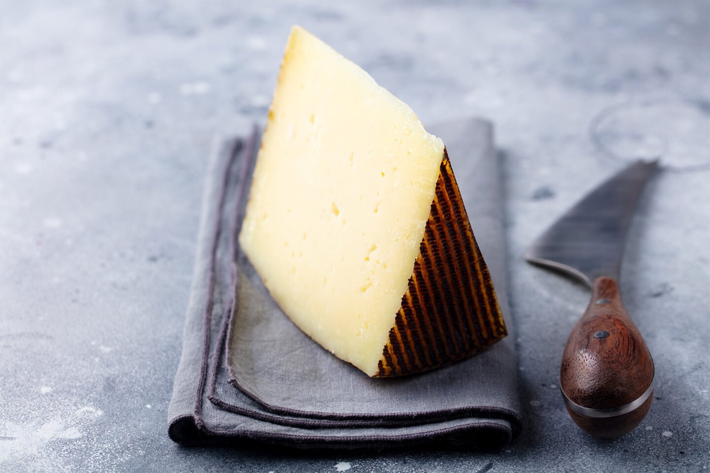 hard cheese manchego on grey stone